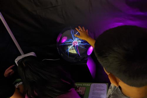 Lincoln student with hand on glowing science discovery globe
